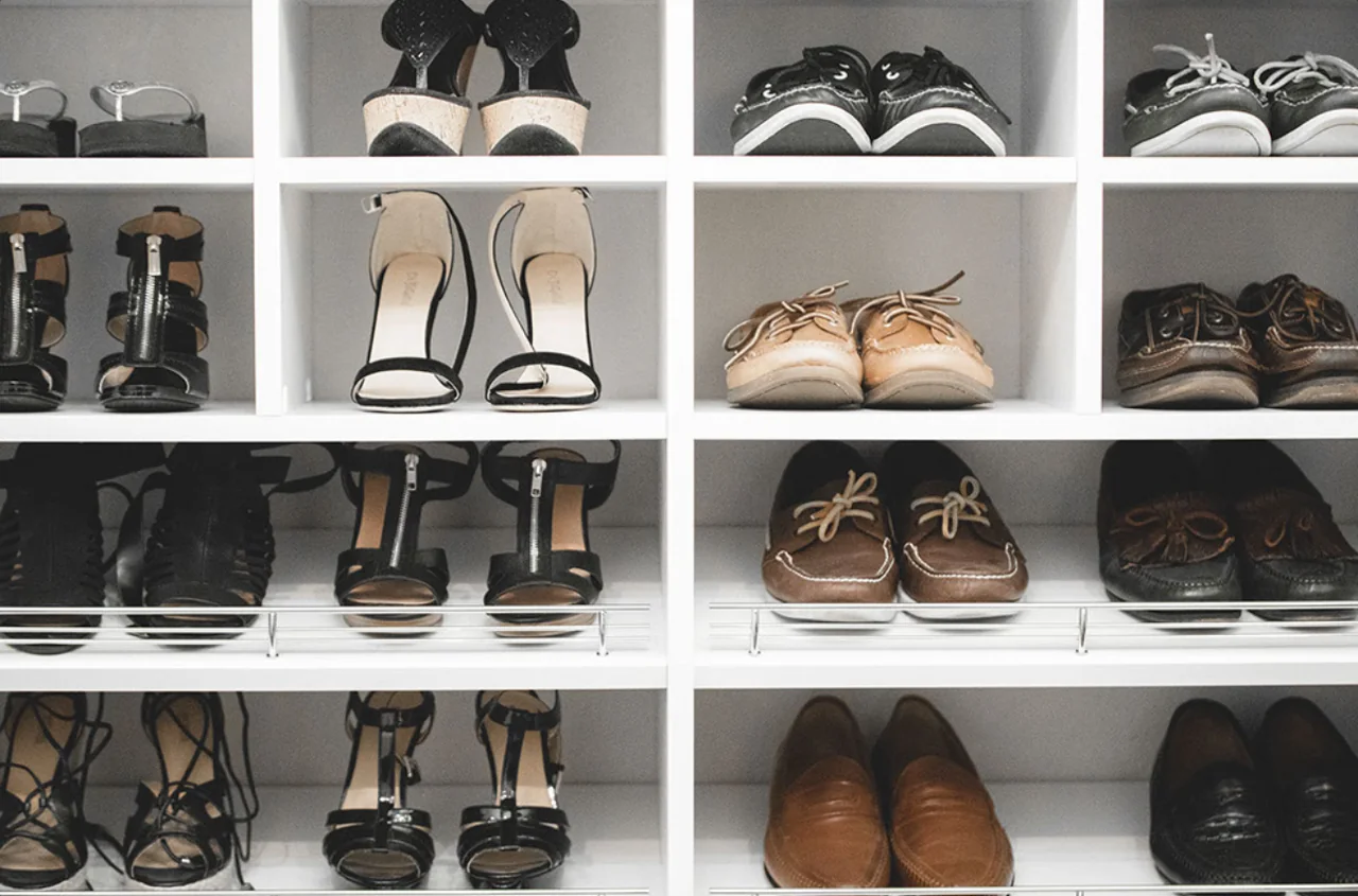 Close-up of white shoe cubbies with shoe fences on the lower shelves