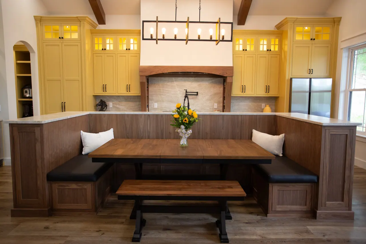 Built-in breakfast nook banquette with dark wood base and cream cabinets