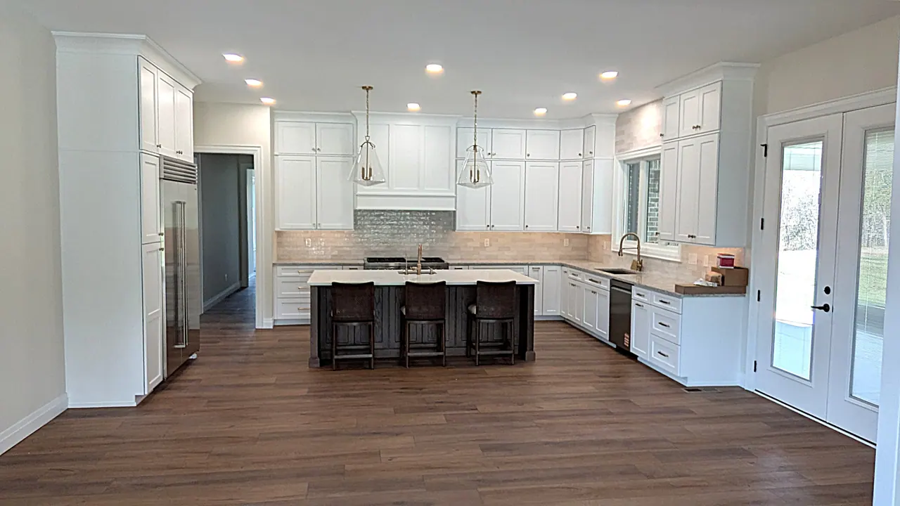 Open white kitchen with dark island
