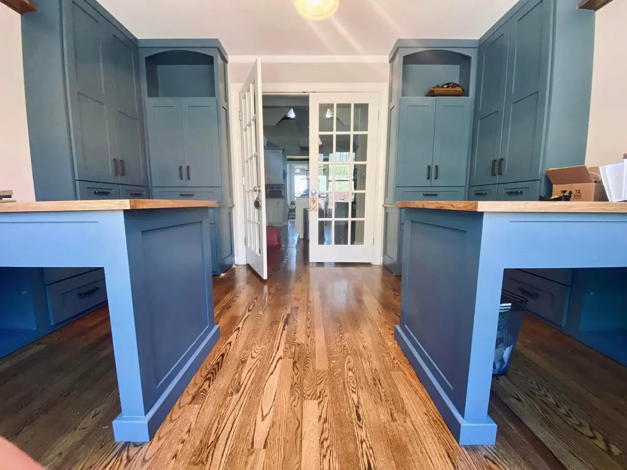 Pair of blue desk built-ins facing French doors