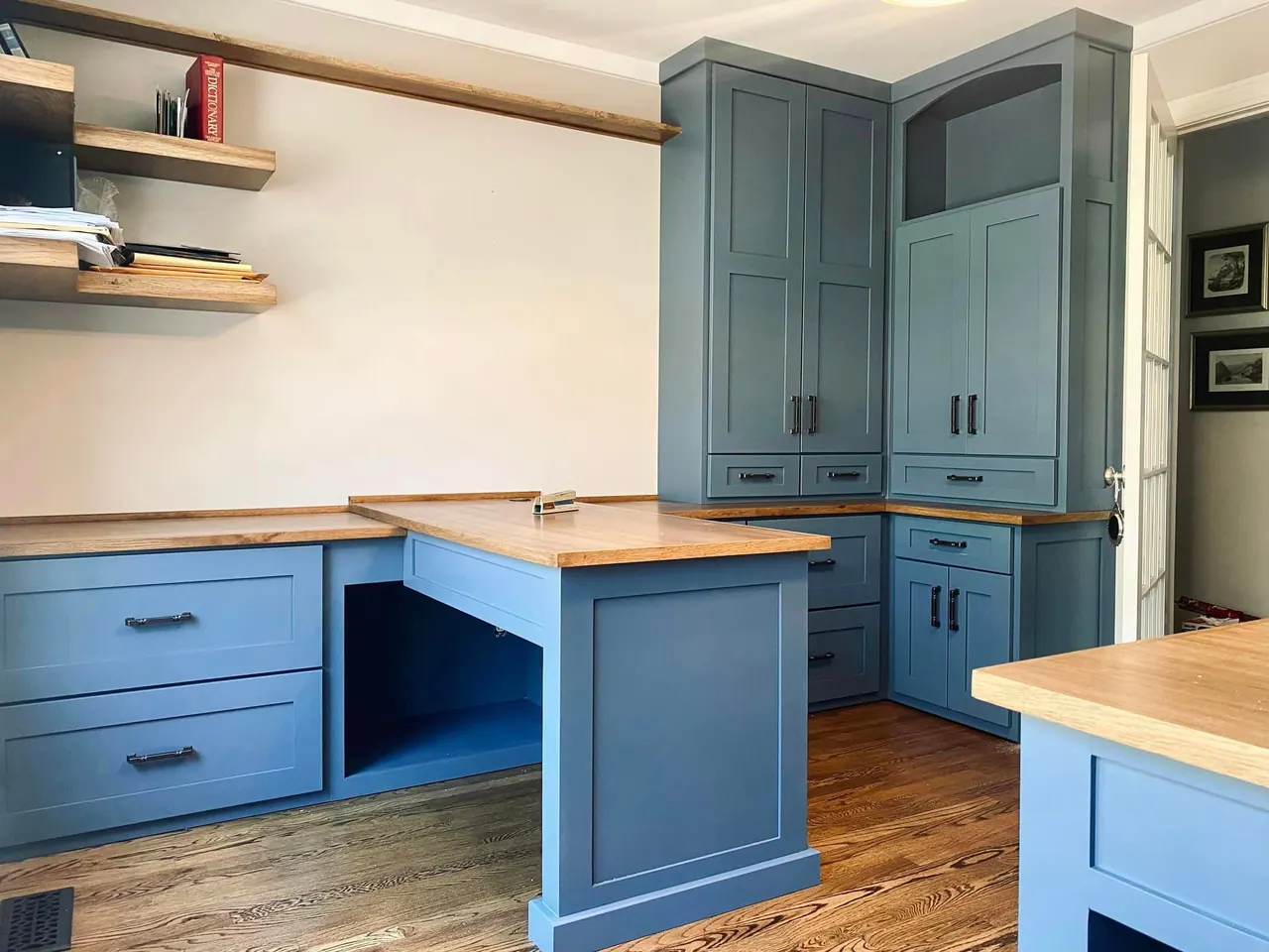 Blue office cabinetry with wood shelves