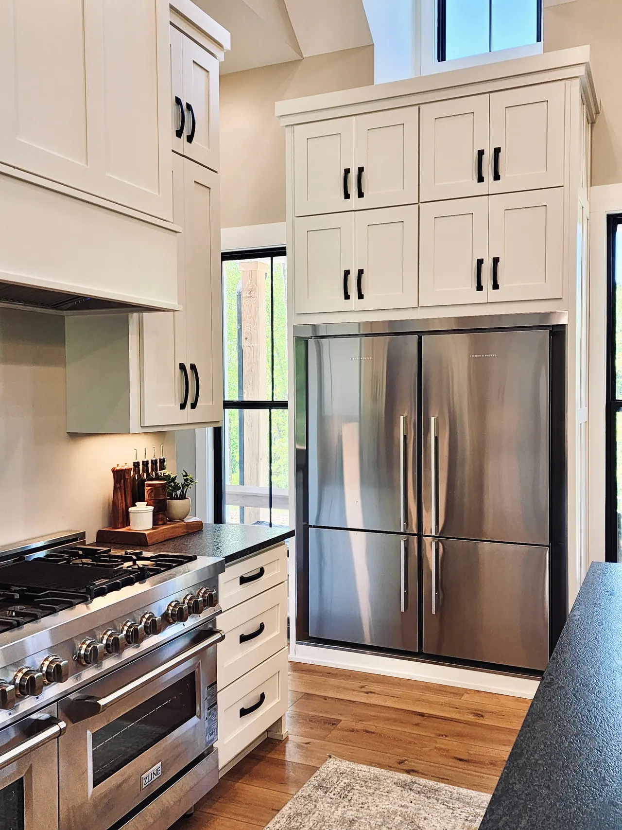 Stacked white cabinets around a stainless refrigerator