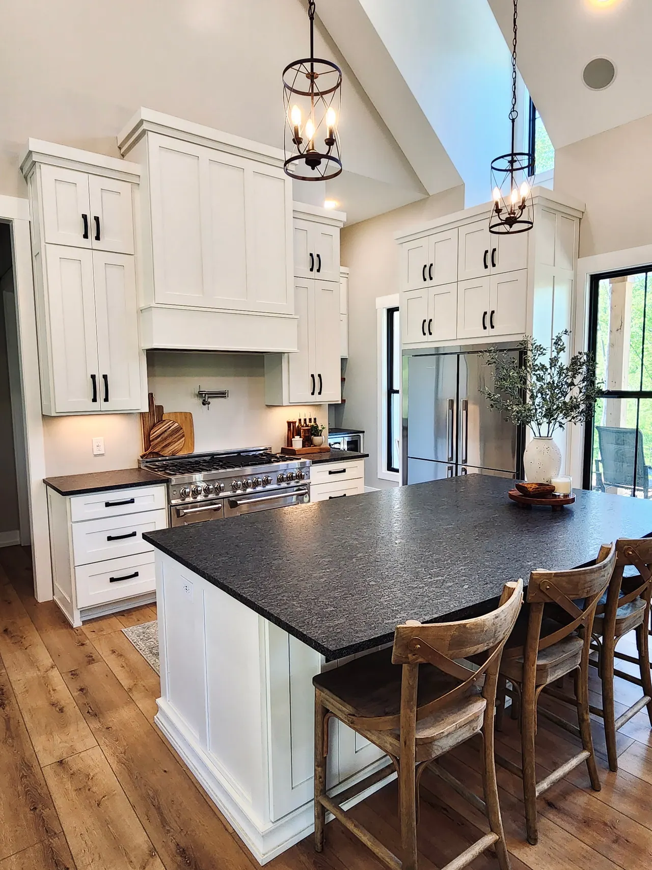 White kitchen with dark countertops and pendant