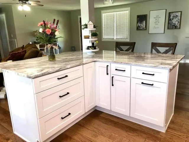 White L-shaped kitchen with granite peninsula