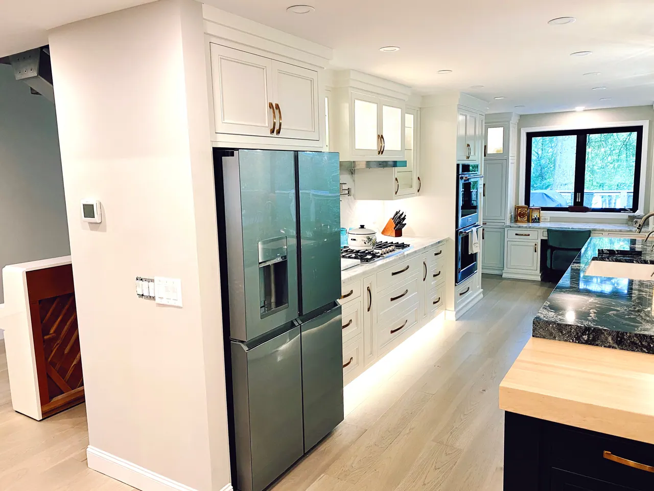 Tall white pantry cabinets and stainless refrigerator