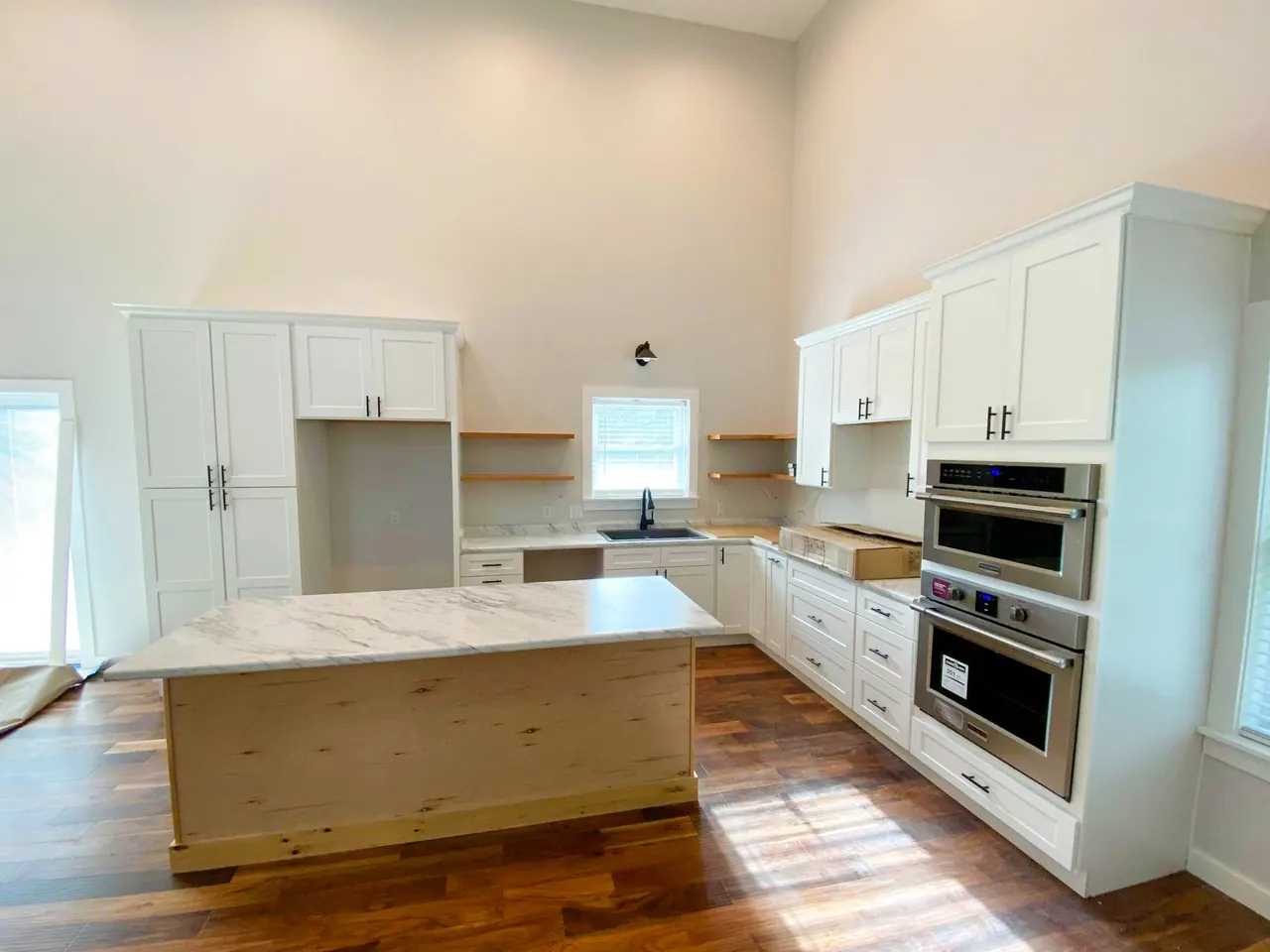 White kitchen with natural wood island in a vaulted room