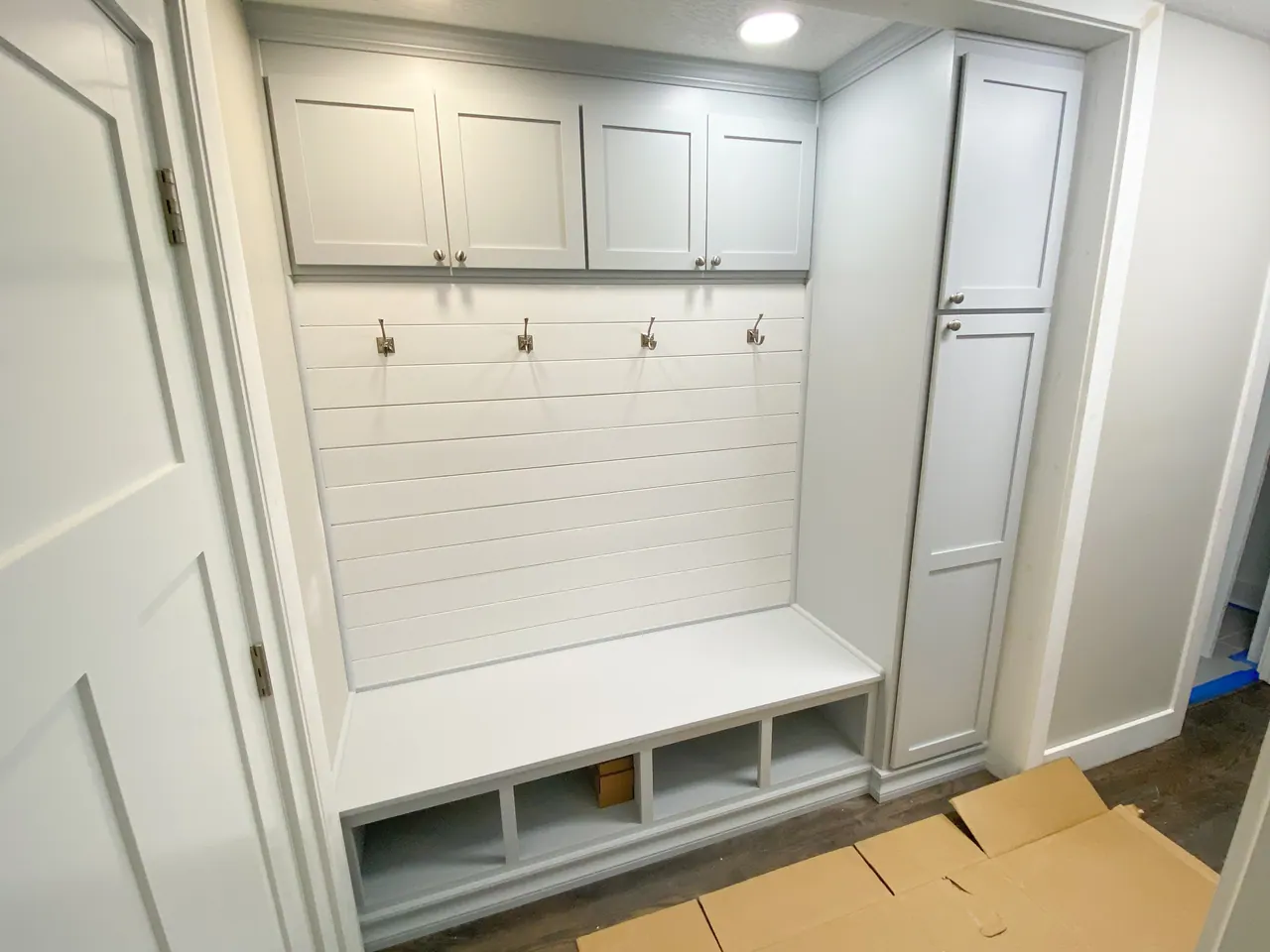 White mudroom bench with tall storage cabinet