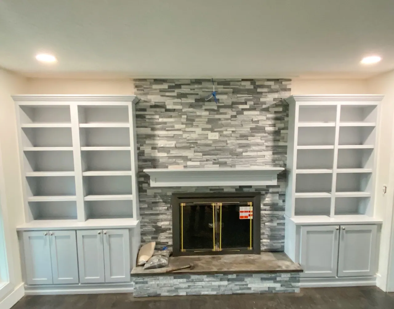 Fireplace flanked by white built-in bookcases