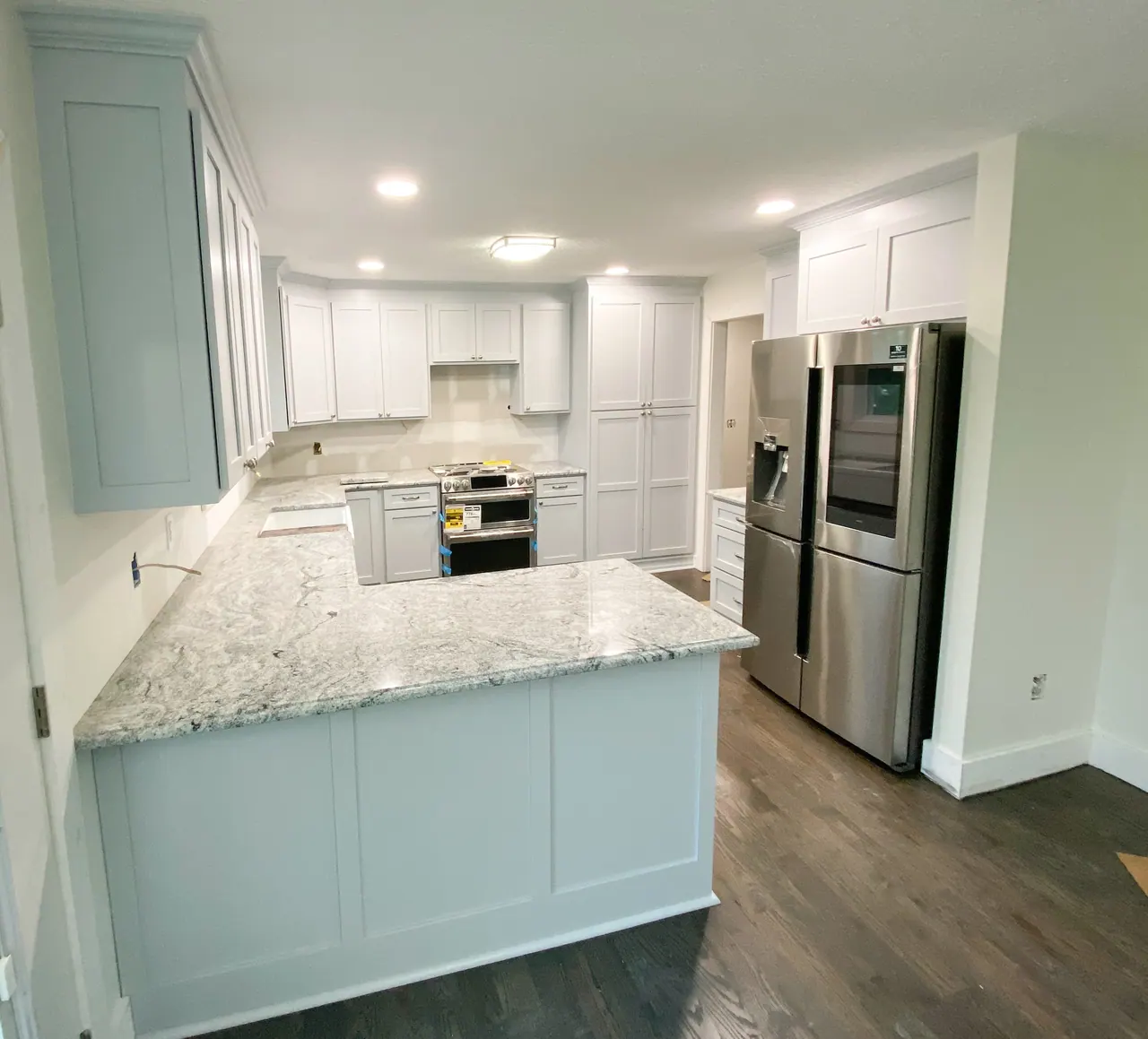 White peninsula kitchen with granite