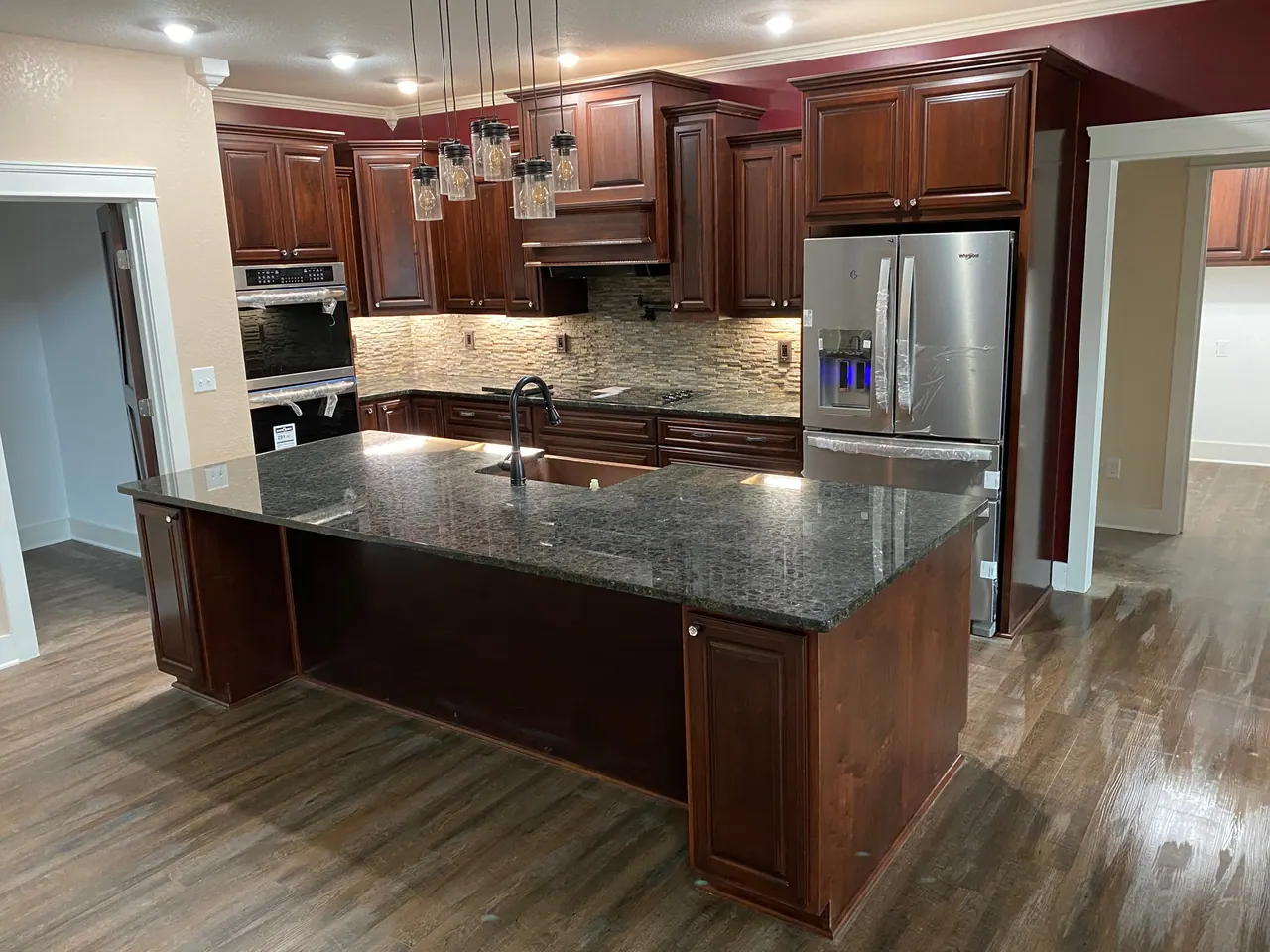 Cherry stained kitchen with dark granite island