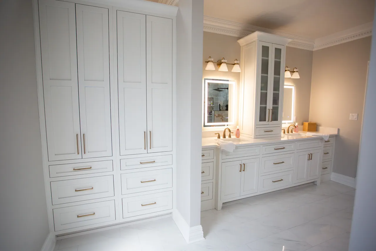 White built-in linen cabinets with tall doors and drawers