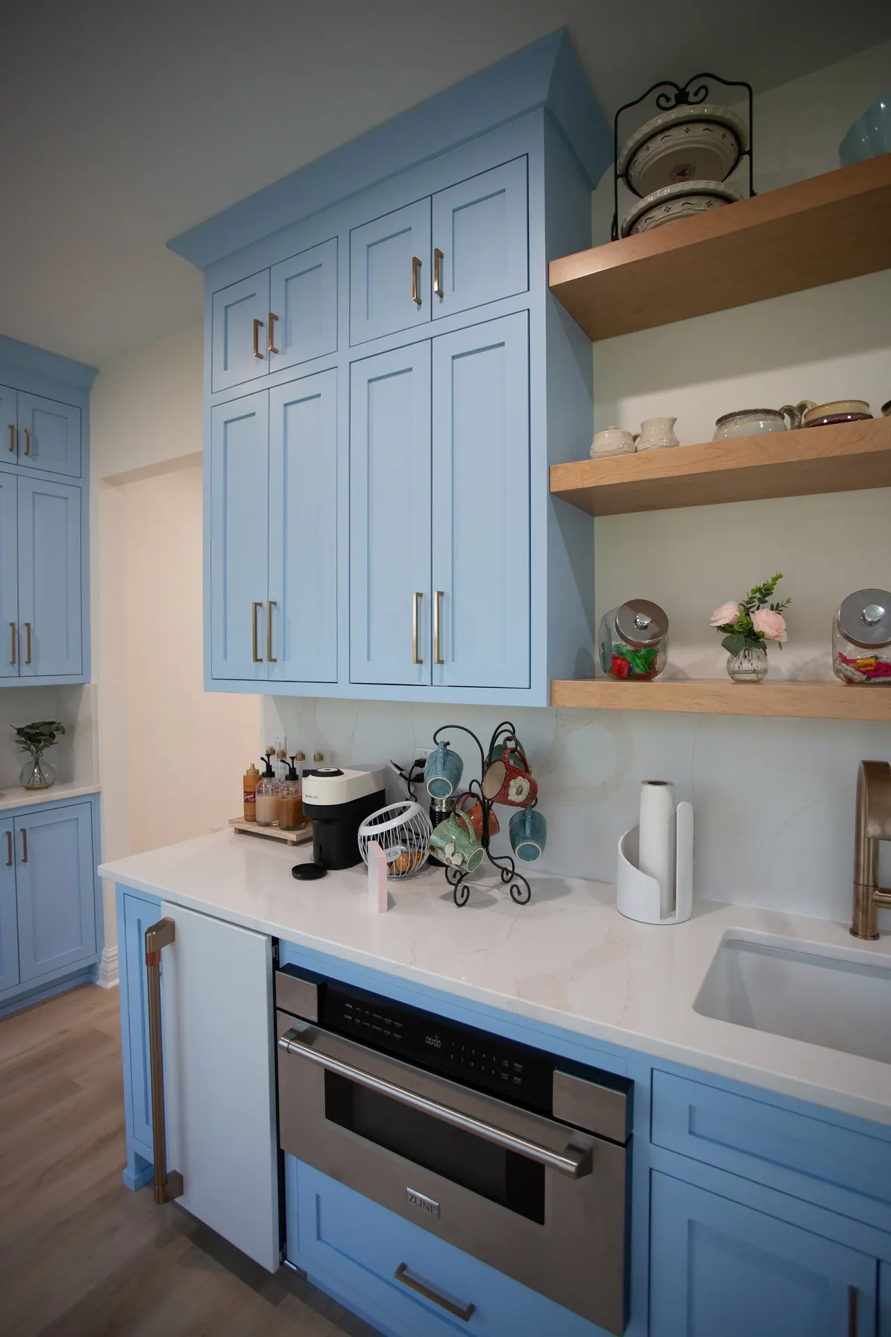 Blue beverage station with open shelving and built-in microwave drawer