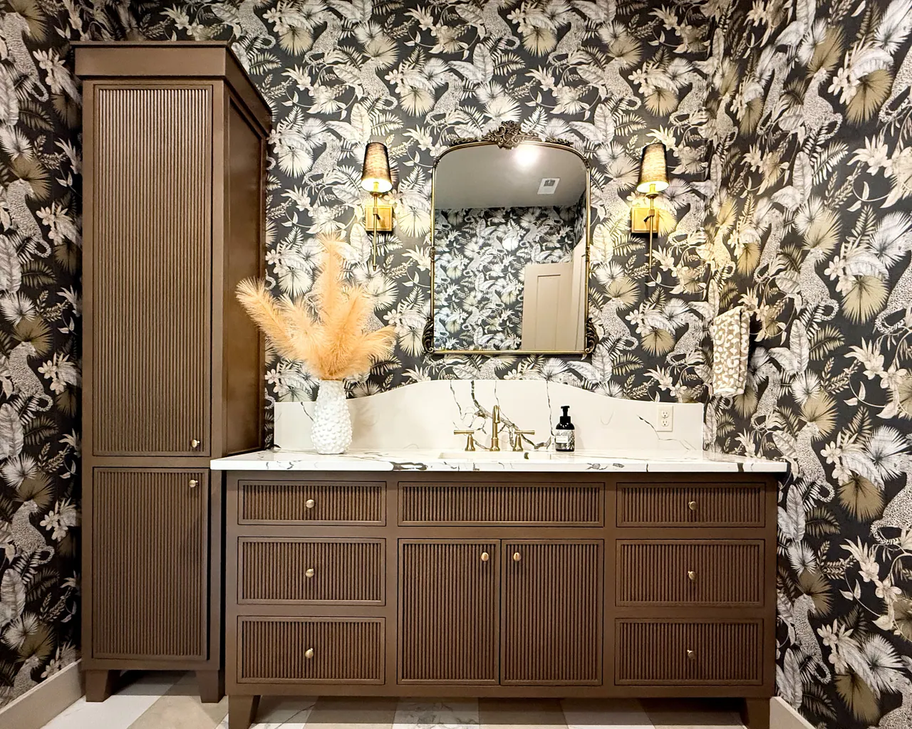 Fluted vanity with linen tower and patterned wallpaper
