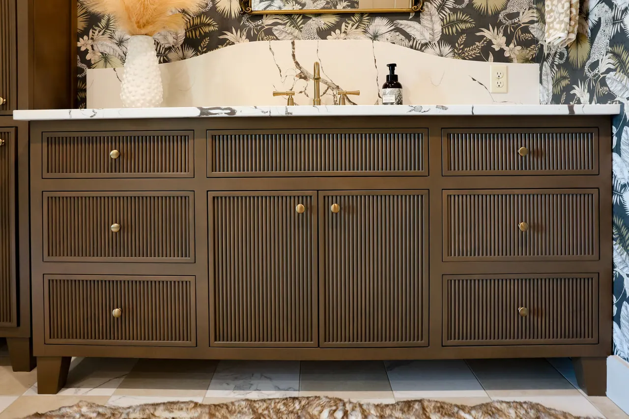 Fluted brown double vanity with marble top against bold wallpaper