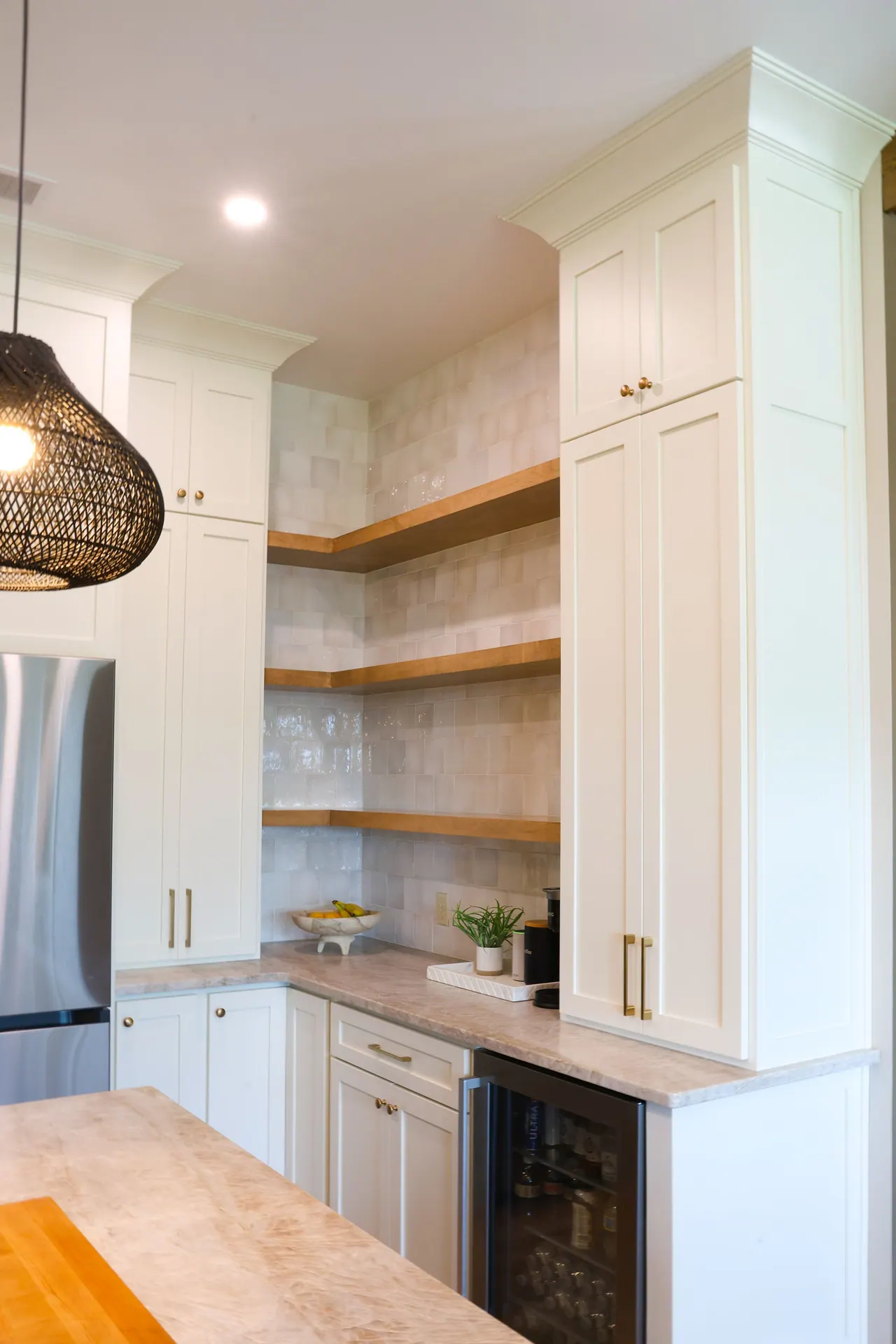 Open shelves and white cabinetry beside a stained wood cabinet